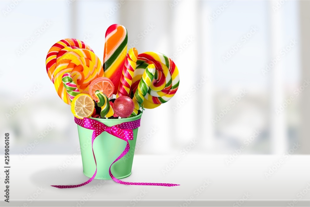 Transparent glass jar with colorful chocolate candies on table