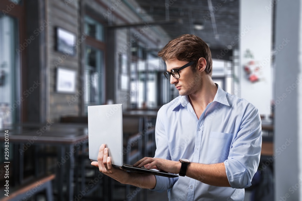 Male hands holding and using laptop