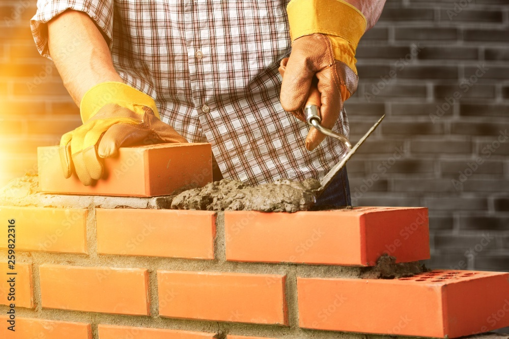 Worker builds a brick wall