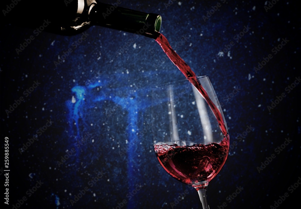 Red wine pouring into glass on background