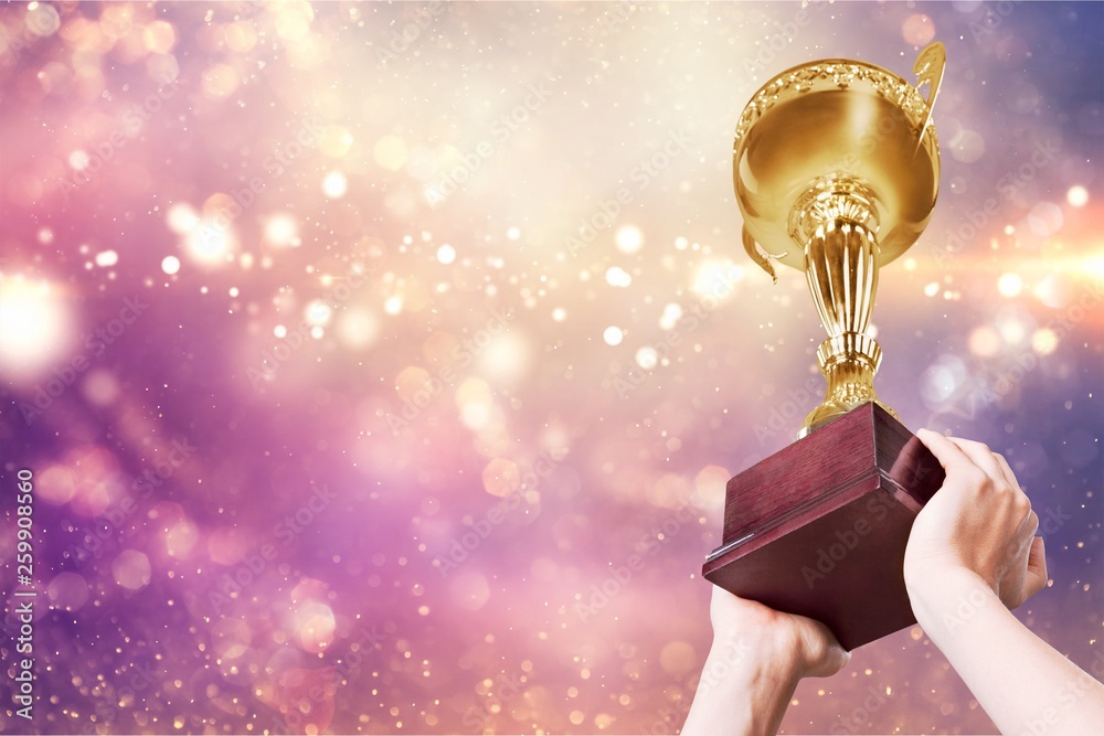 Hands holding golden trophy on a white background