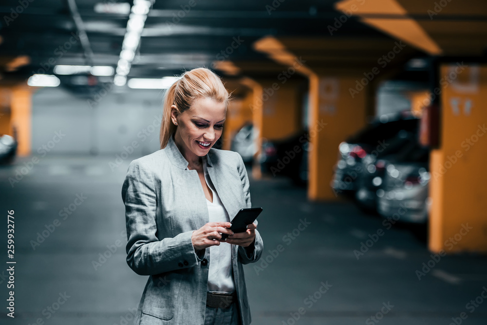 成功女性在地下停车场使用电话。