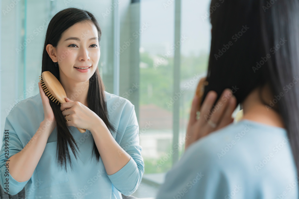 美丽的亚洲女性化妆和发型，浴室里有镜子，有晨光