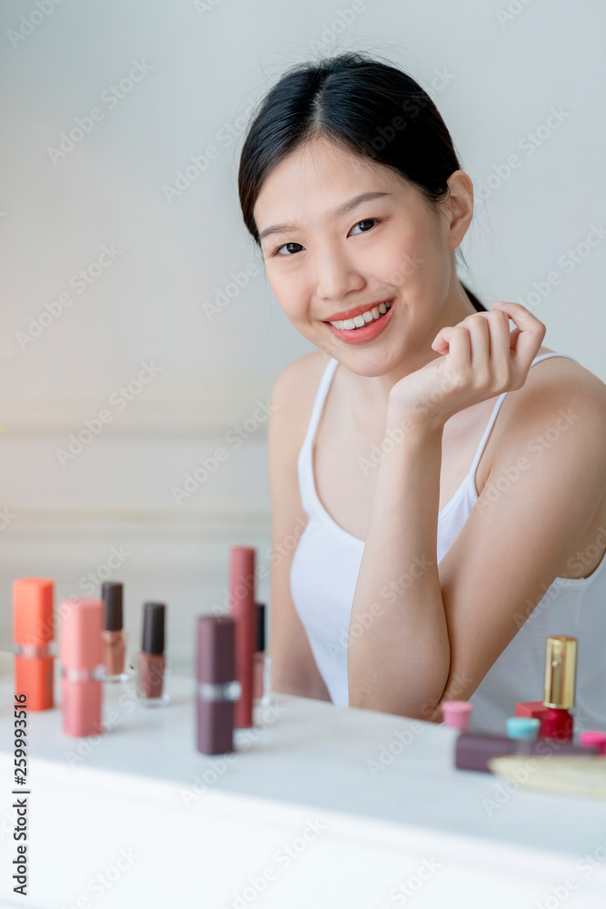 beautiful asian woman white tshirt smile with happiness hand hold blush on and makeup cosmetic items