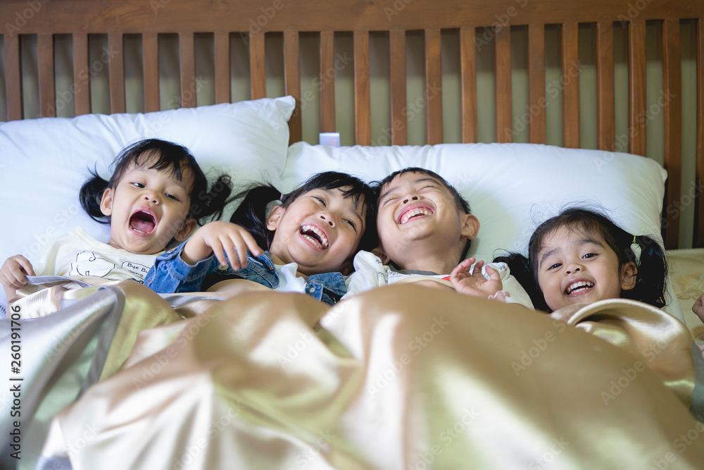 Happy children having fun in the bedroom. brother and sister wake up in the morning with happiness.