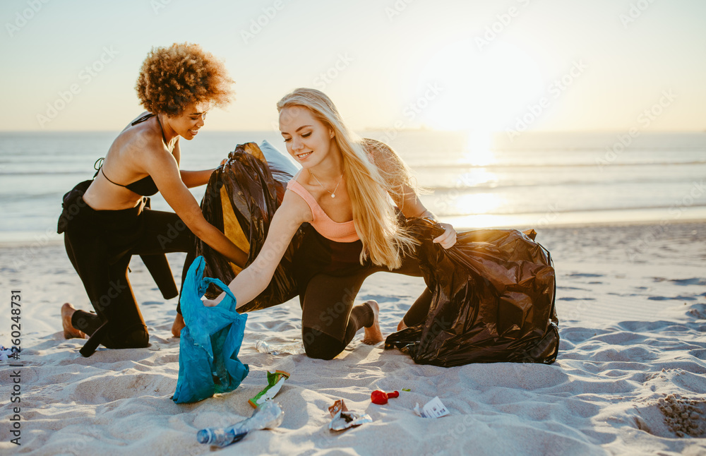 Women cleaning up a sandy beach