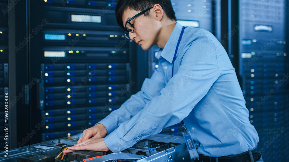 In the Modern Data Center: IT Technician Working with Server Racks, on a Pushcart Installing New Har