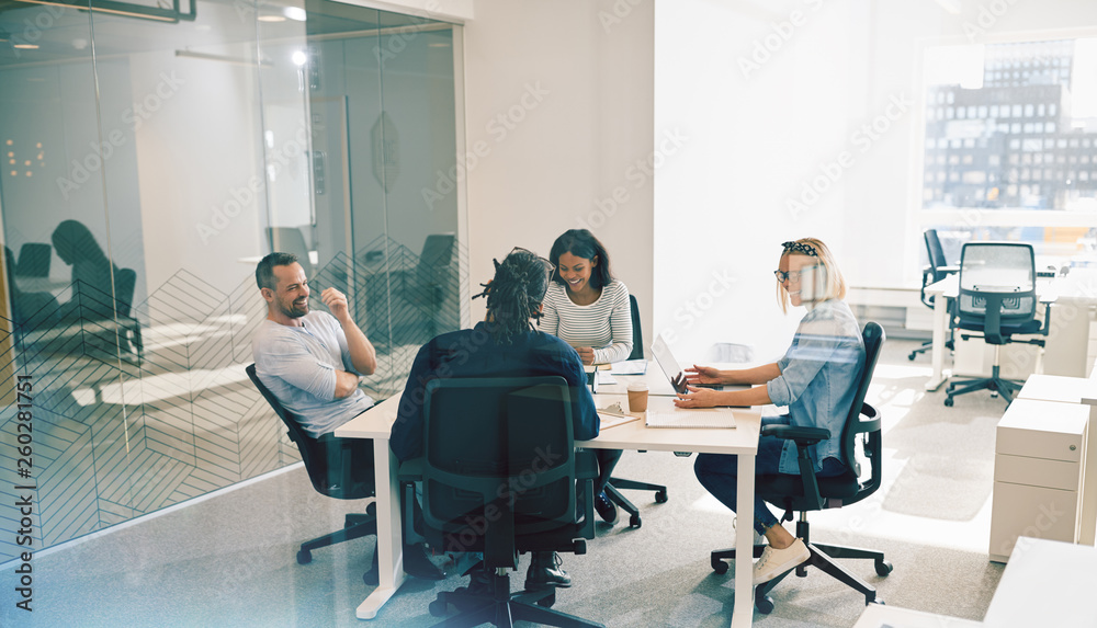 Laughing group of office colleagues having an work meeting toget