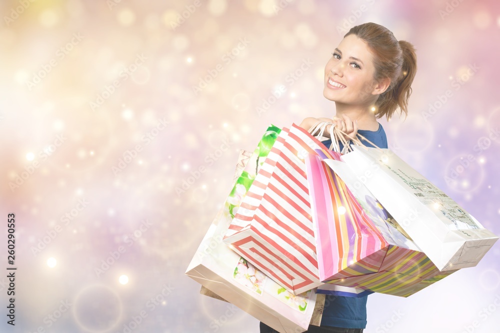 Young woman with shopping bags on blurred shopping mall background