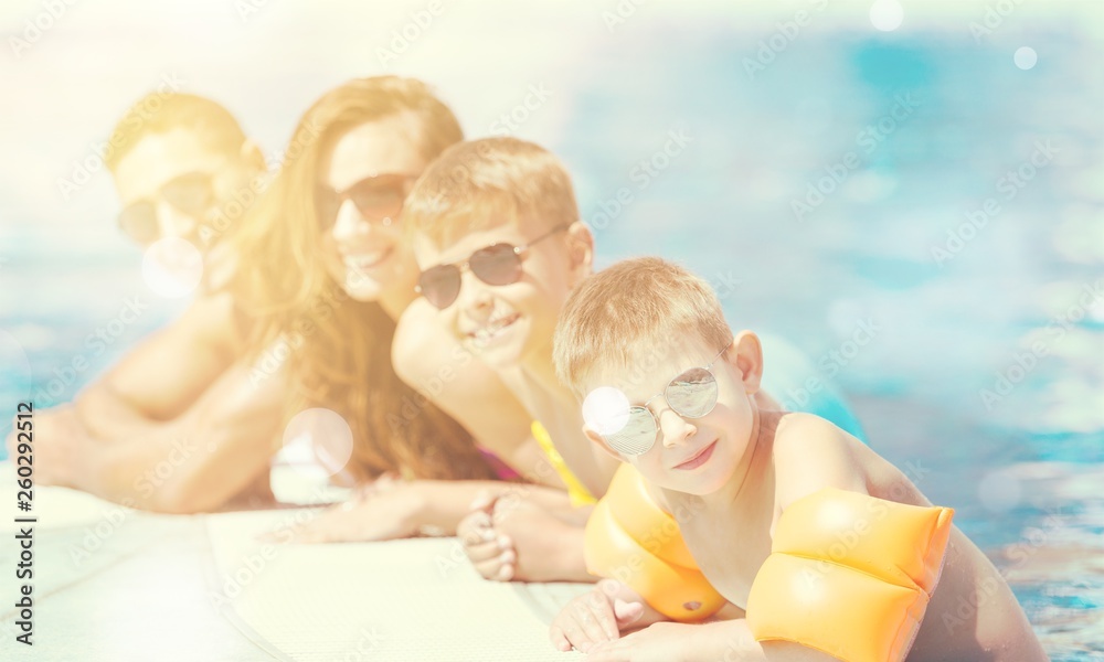 Happy family playing in swimming pool. Summer vacation concept