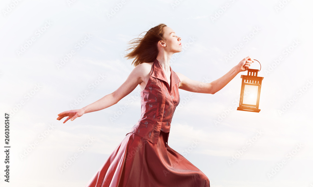 Attractive girl muse with old lantern in hand at summer day