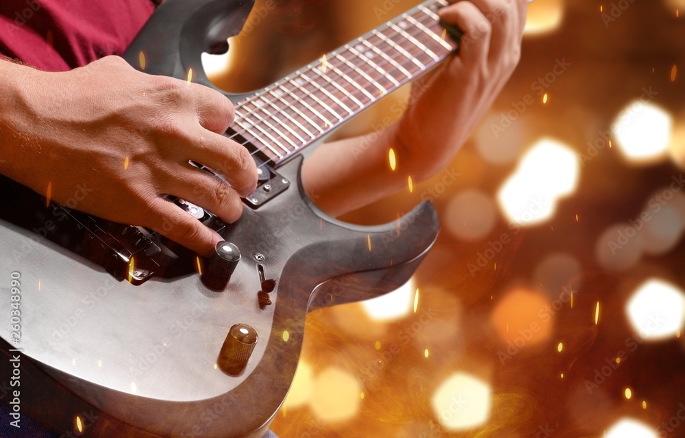 Male Guitarist playing music on background