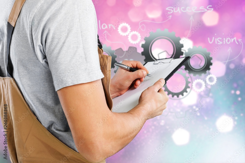 Worker writing on paperclip, close up,on background