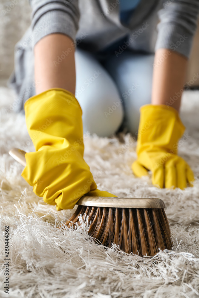 Woman cleaning carpet at home