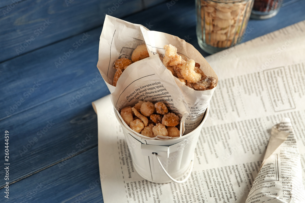 Tasty sugared nuts on wooden table