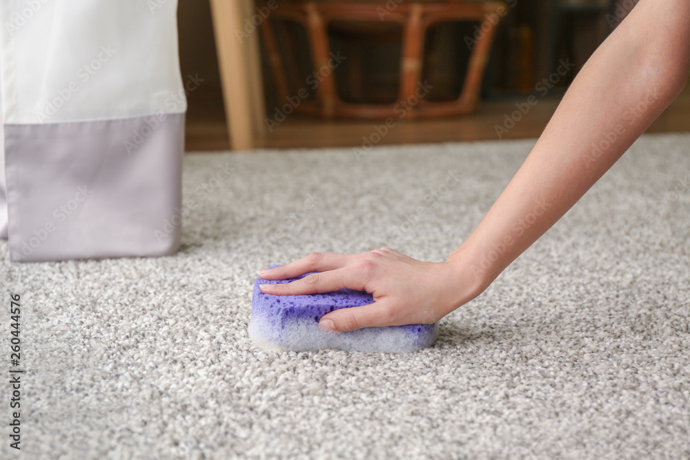 Woman cleaning carpet at home