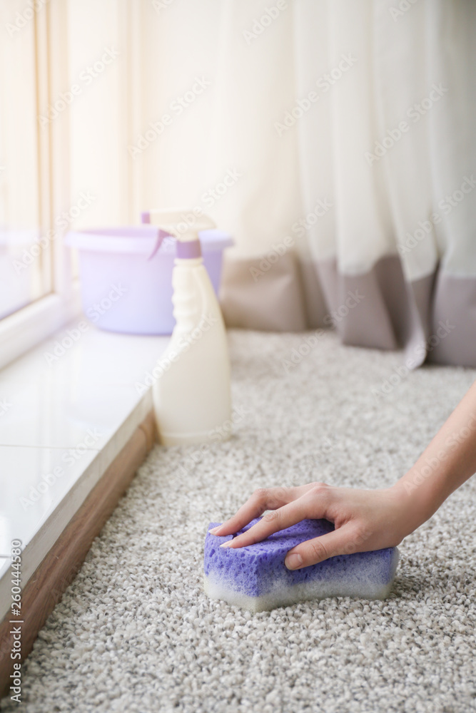 Woman cleaning carpet at home