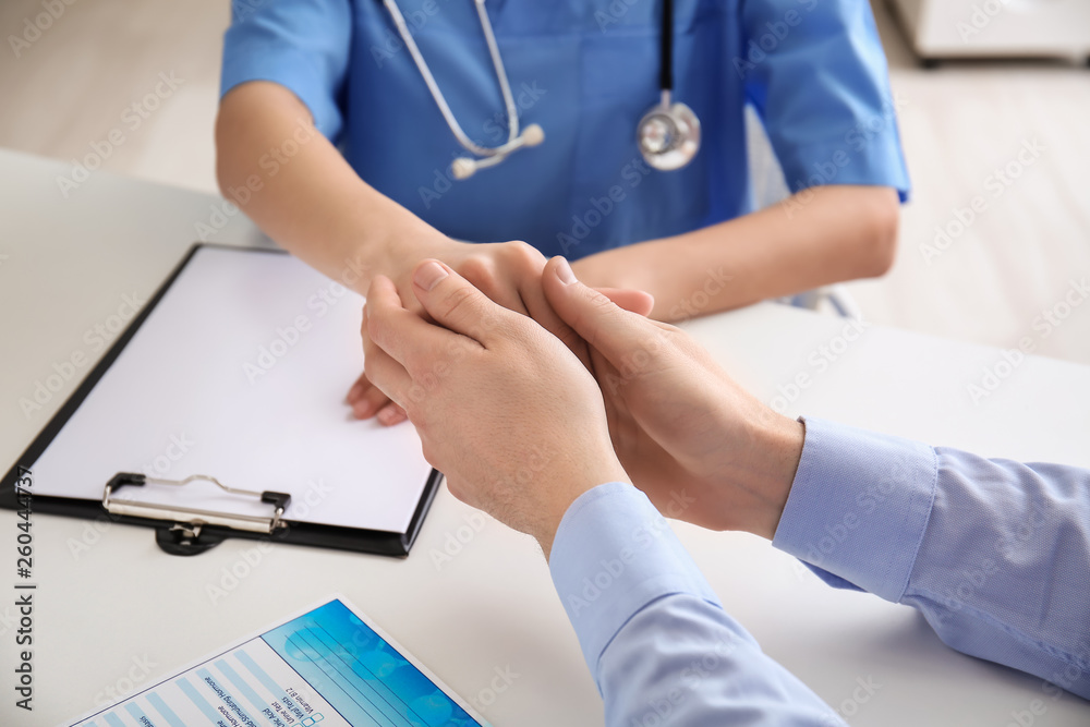 Female doctor comforting her patient in clinic