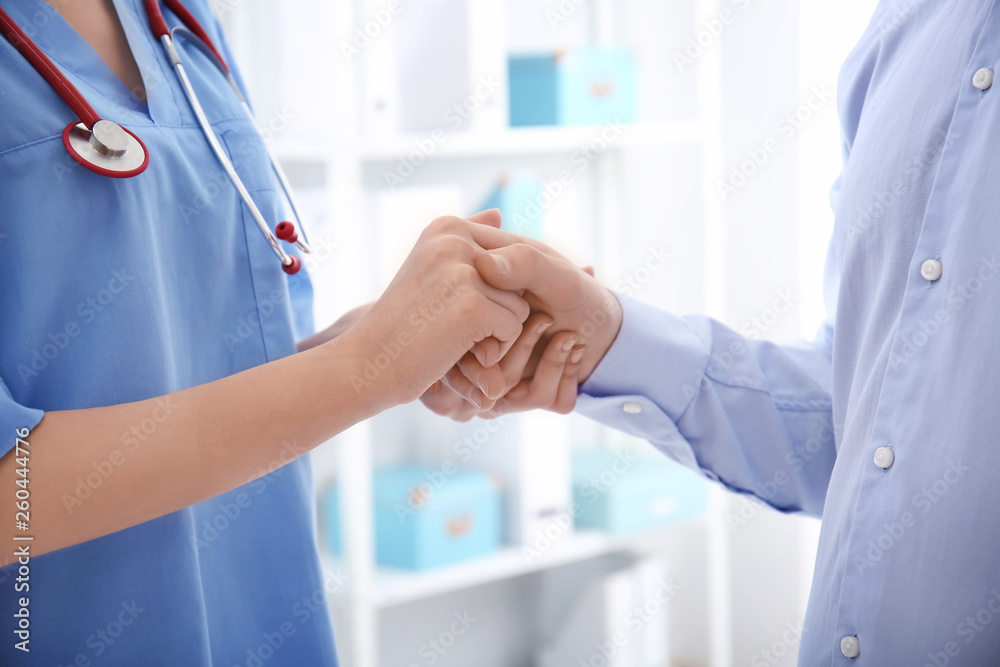 Female doctor comforting her patient in clinic