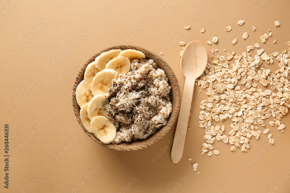 Bowl with tasty sweet oatmeal on color background