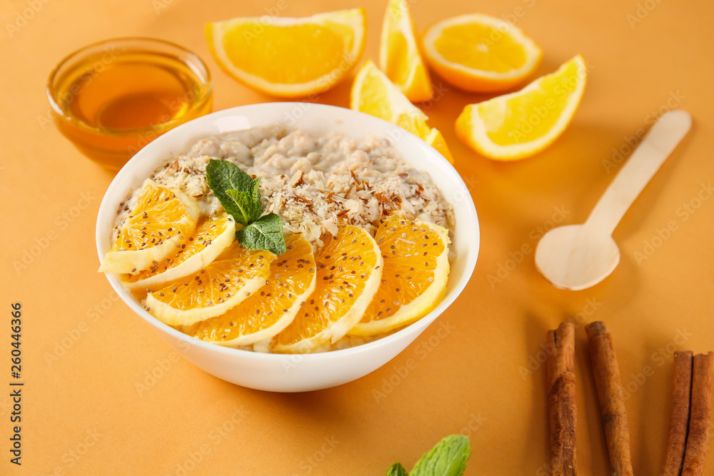 Bowl with tasty sweet oatmeal on color background