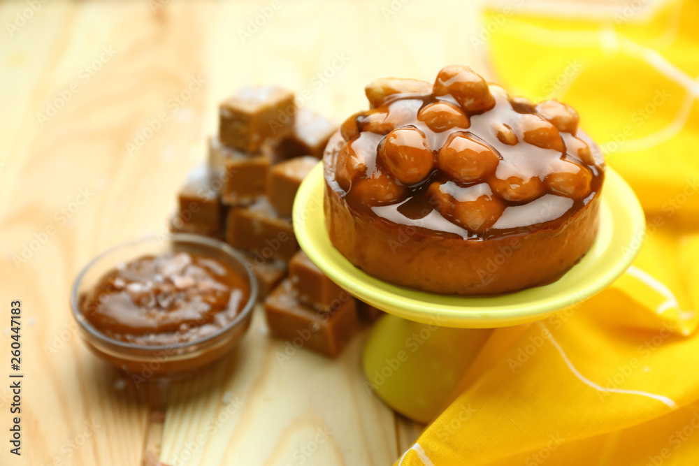 Tasty cake with caramel on wooden table