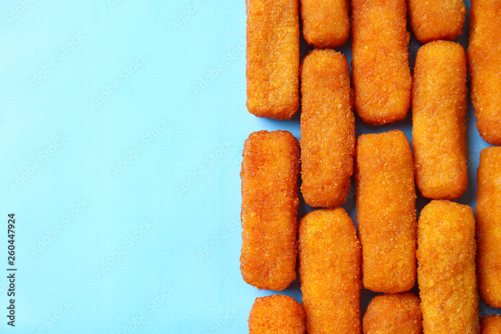 Tasty mozzarella sticks on color background