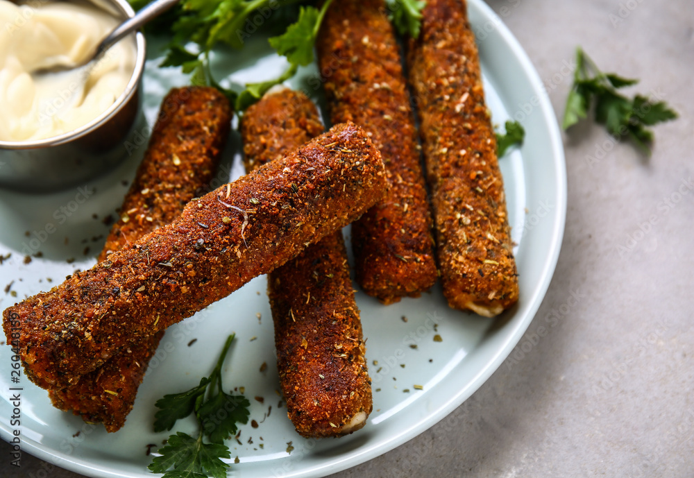 Tasty mozzarella sticks and sauce on plate, closeup