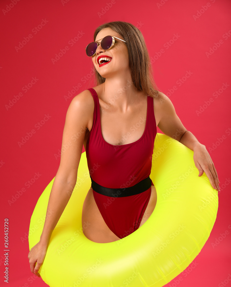 Beautiful young woman with inflatable ring on color background