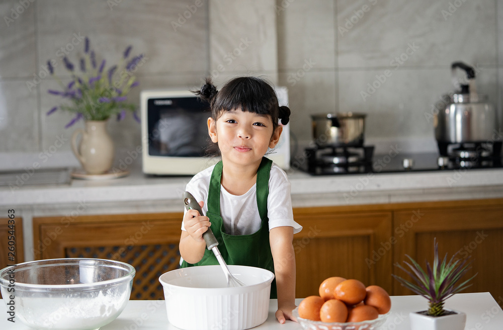 Happy Asian kid is preparing the dough, bake cookies in the Kitchen. bakery  concept.