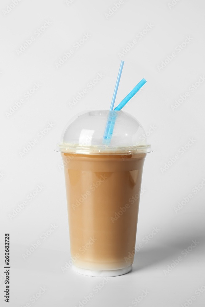 Cup of tasty frappe coffee on light background