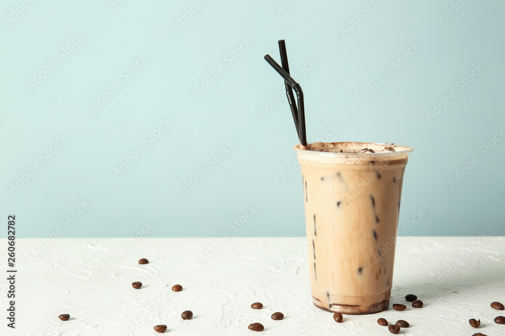 Cup of tasty frappe coffee on white table