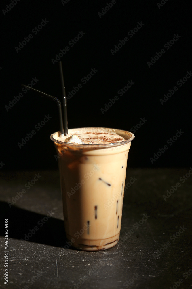 Cup of tasty frappe coffee on dark table