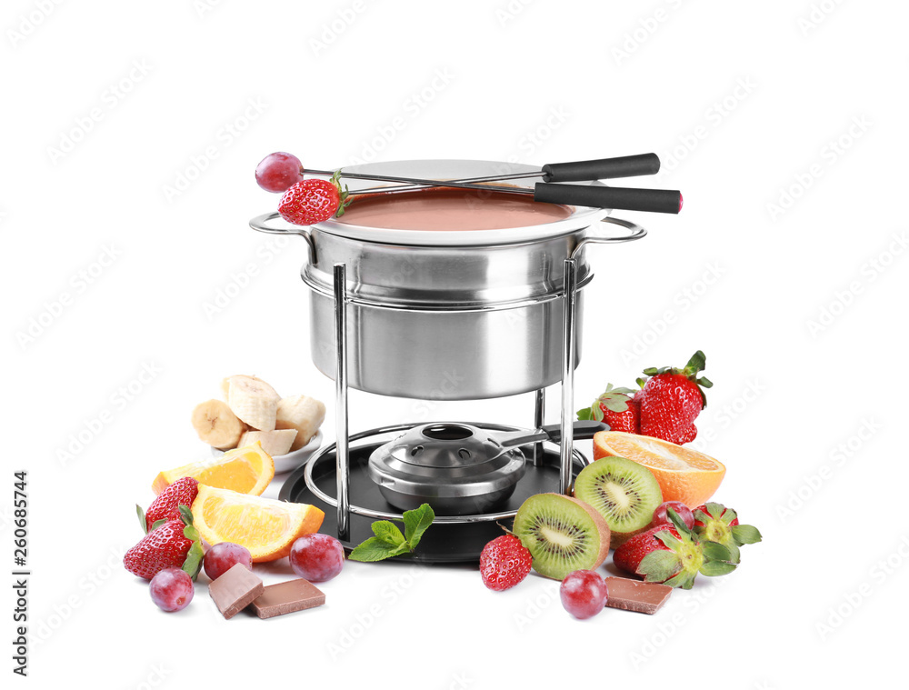 Fondue pot with melted chocolate and fruits on white background