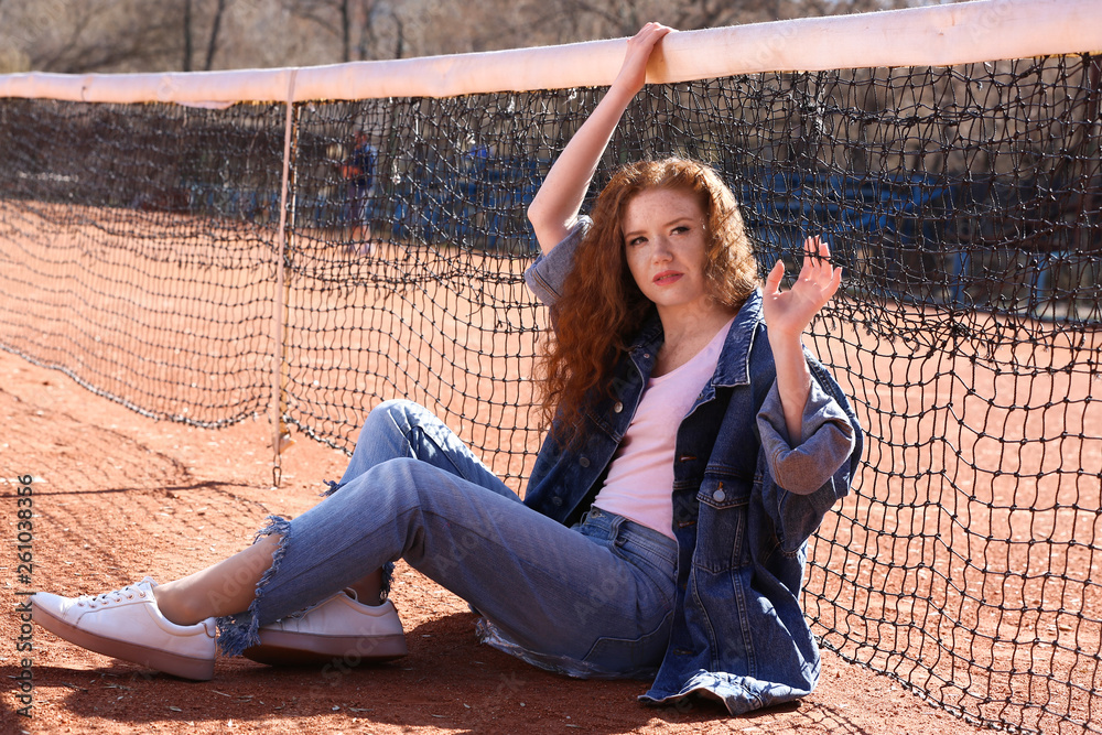 Fashionable young woman on tennis court outdoors