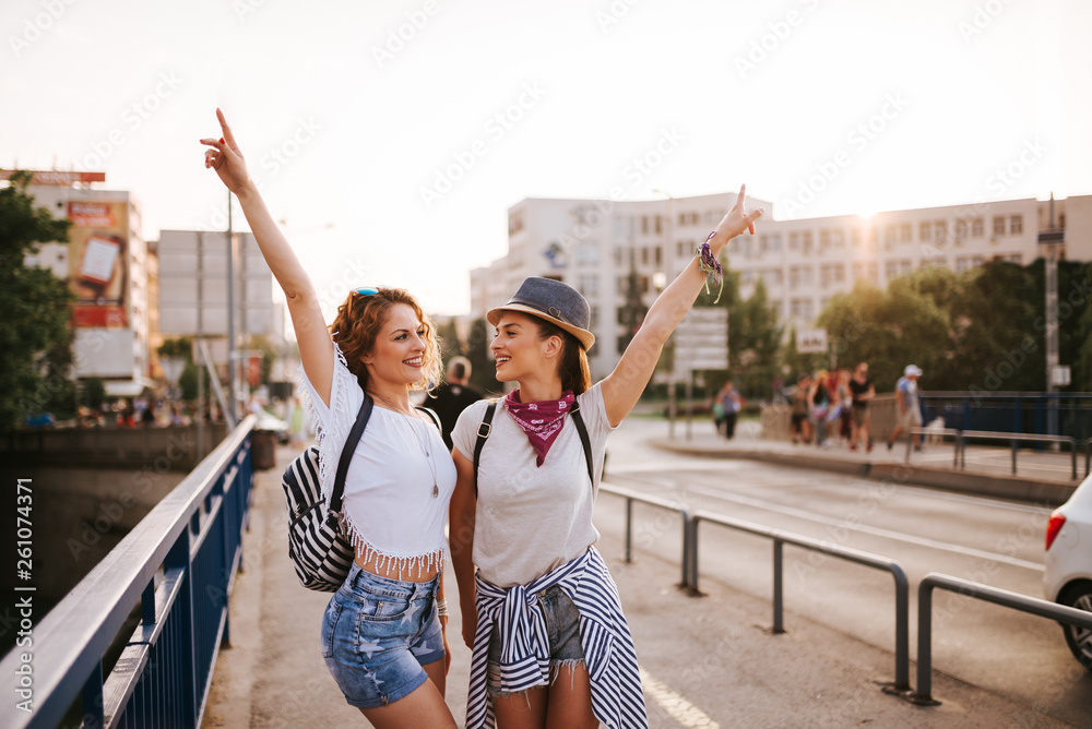 女孩们在阳光明媚的城市桥上跳舞，玩得很开心。