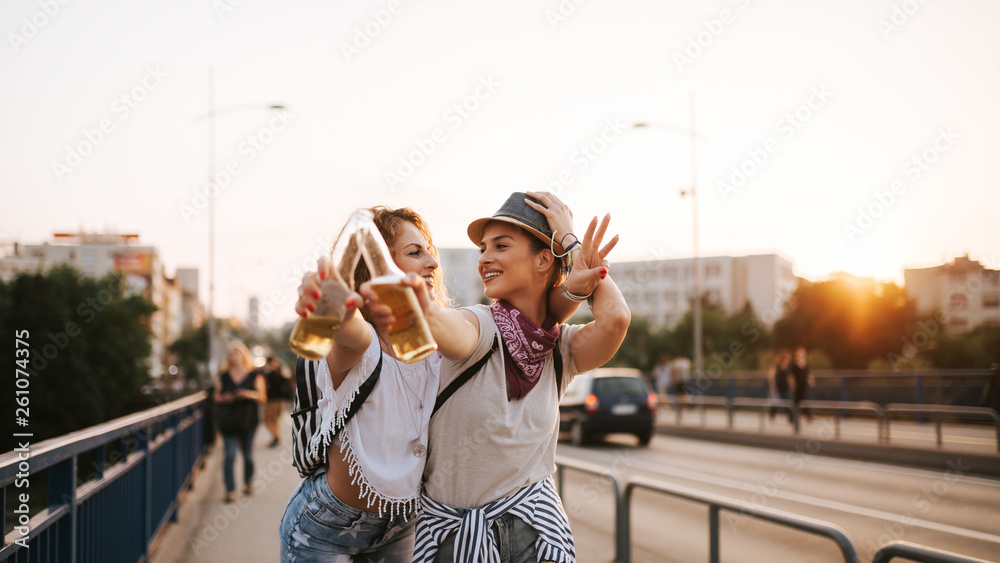 两个漂亮女孩举杯庆祝的时尚生活方式城市肖像。