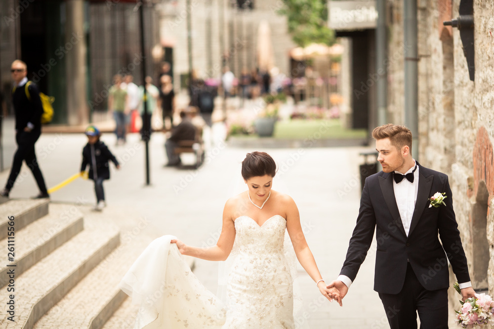 Bride and groom walking in the city, wedding day, marriage concept. Bride and groom in urban backgro