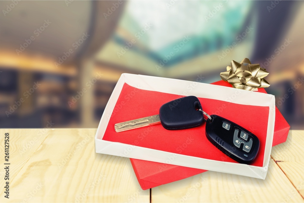 Modern Car keys  as a gift on  background