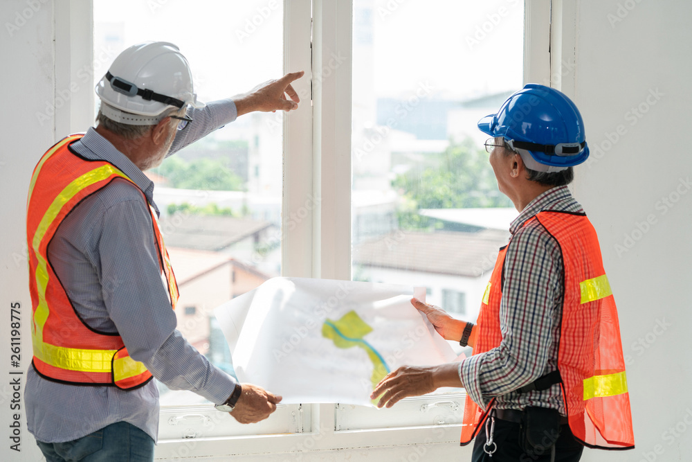 Senior engineers and architect working with construction plan. House building concept.