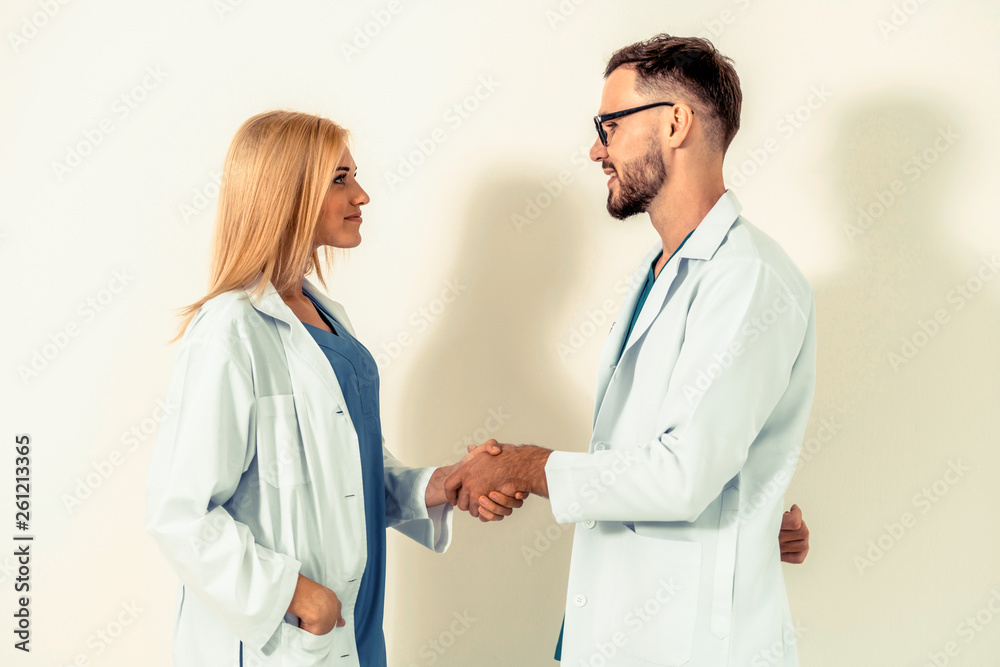 GP doctor shake hand with surgical doctor on white background.