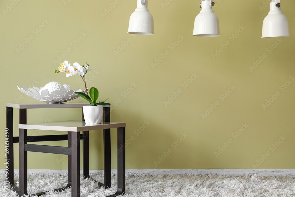 Tables with decor near color wall