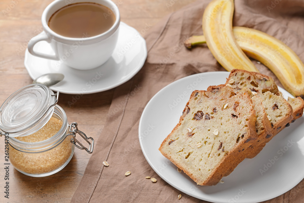 Tasty banana bread with cup of coffee on wooden table