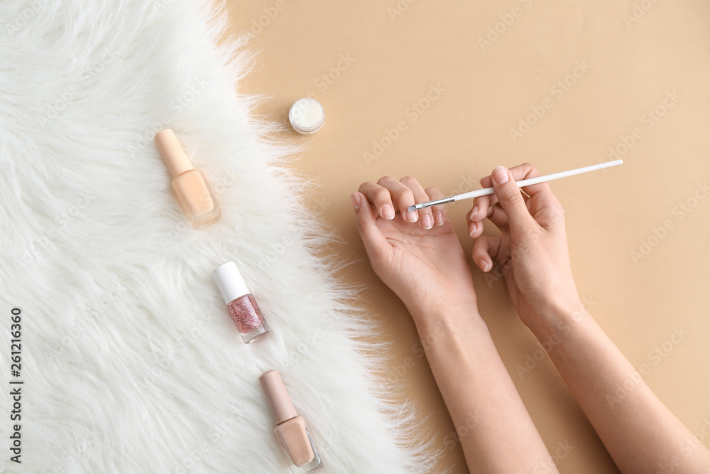 Woman doing manicure on color background