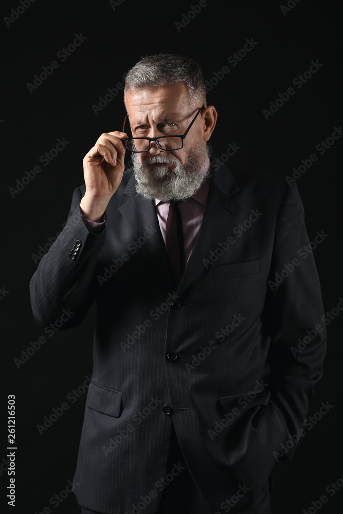 Handsome mature businessman on dark background