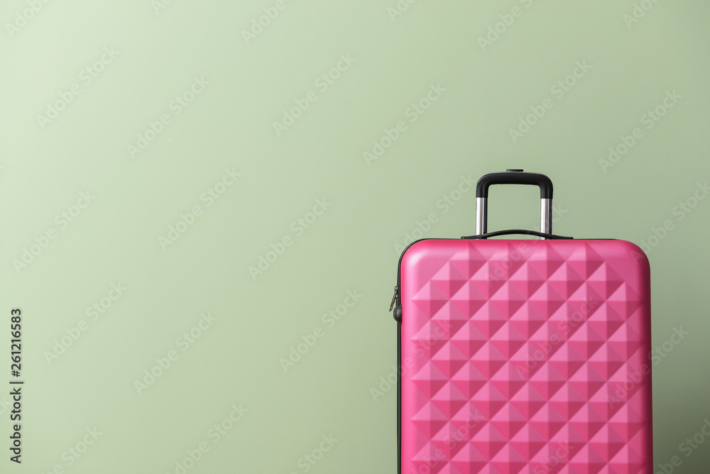 Packed suitcase on color background