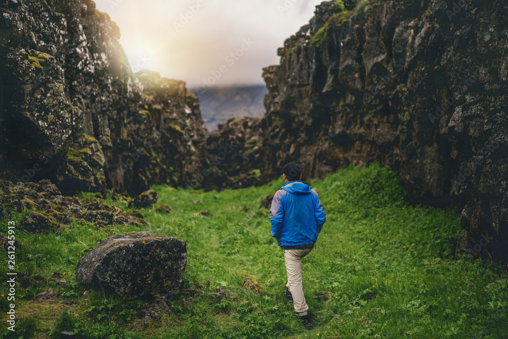 Man traveler and explorer travels in the Icelandic landscape hiking across Iceland to discover uniqu