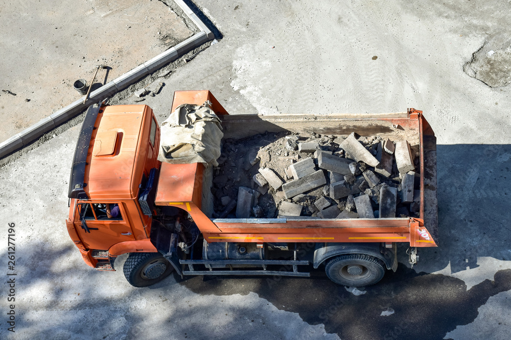 重型工业自卸车。城市道路建设和更新现场。自卸车运到瑞拜