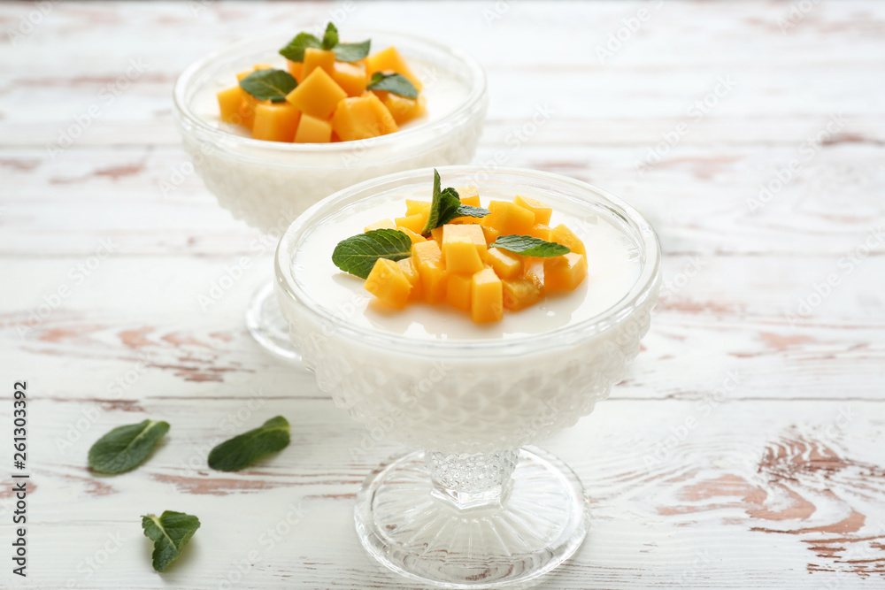 Bowls of delicious panna cotta on white table