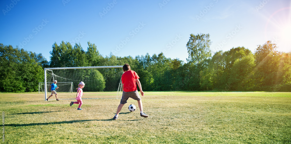 Boys playing football on the field with gates